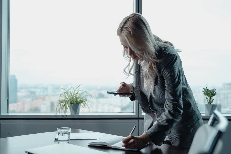 Osoba zapisující si poznámky do zápisníku během přednášky